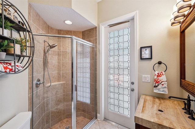 bathroom with walk in shower, tile patterned floors, vanity, and toilet