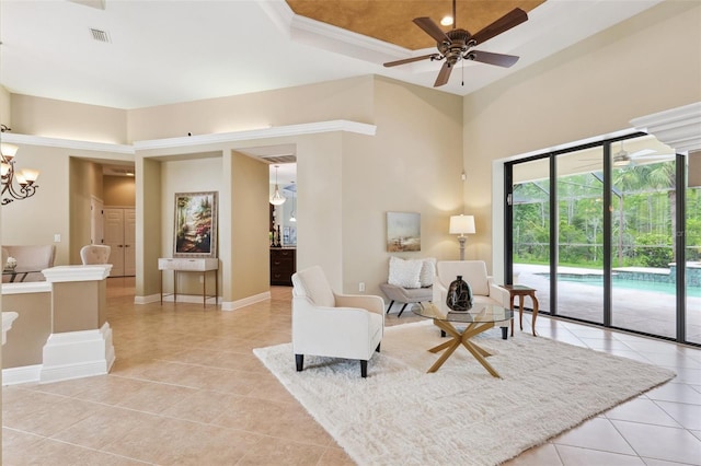 20200 Lace Cascade Rd, Land O Lakes, FL 34637 - living room featuring light tile patterned flooring, a tray ceiling, a chandelier, a ceiling fan, and baseboards