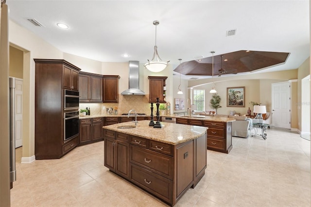 20200 Lace Cascade Rd, Land O Lakes, FL 34637 - kitchen featuring wall chimney exhaust hood, a kitchen island with sink, backsplash, pendant lighting, and recessed lighting