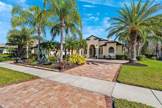 20200 Lace Cascade Rd, Land O Lakes, FL 34637 - mediterranean / spanish home with stucco siding, decorative driveway, and a front yard