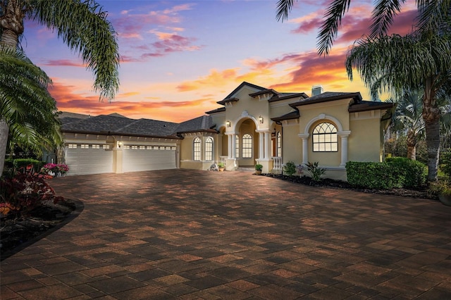 20200 Lace Cascade Rd, Land O Lakes, FL 34637 - mediterranean / spanish home featuring a garage, stucco siding, and decorative driveway