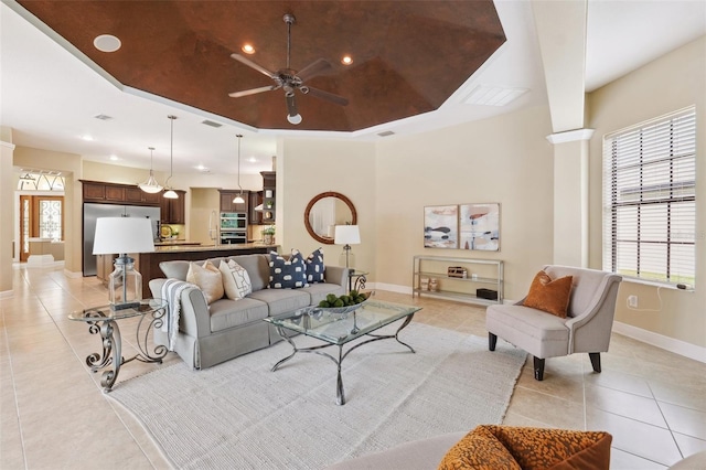 20200 Lace Cascade Rd, Land O Lakes, FL 34637 - living area with light tile patterned flooring, ceiling fan, a tray ceiling, baseboards, and plenty of natural light
