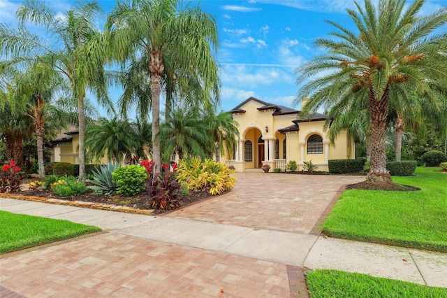 20200 Lace Cascade Rd, Land O Lakes, FL 34637 - mediterranean / spanish-style home with stucco siding, decorative driveway, and a front lawn