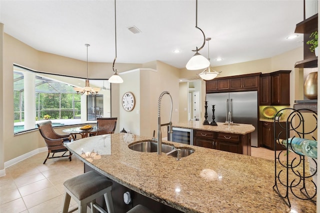 20200 Lace Cascade Rd, Land O Lakes, FL 34637 - kitchen featuring a sink, baseboards, dark brown cabinets, light stone countertops, and light tile patterned floors
