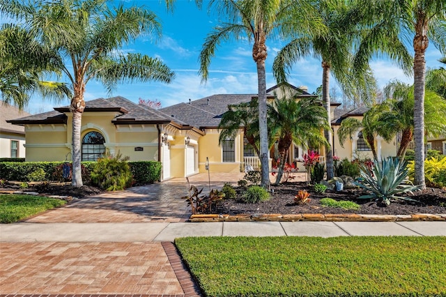 20200 Lace Cascade Rd, Land O Lakes, FL 34637 - mediterranean / spanish-style house featuring stucco siding, decorative driveway, a garage, and roof with shingles