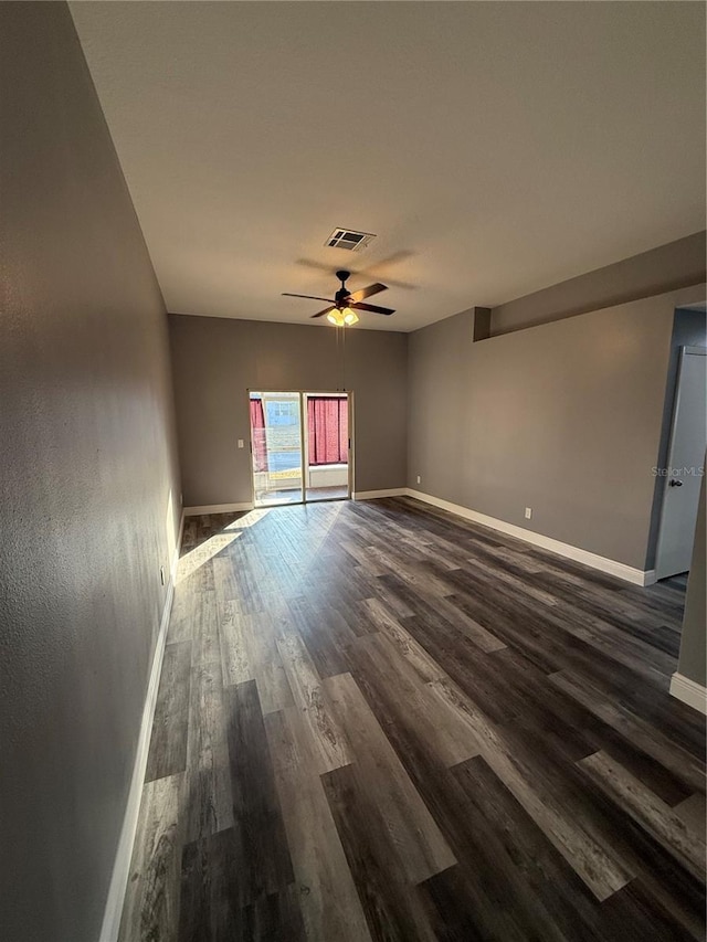 empty room with dark wood-type flooring and ceiling fan