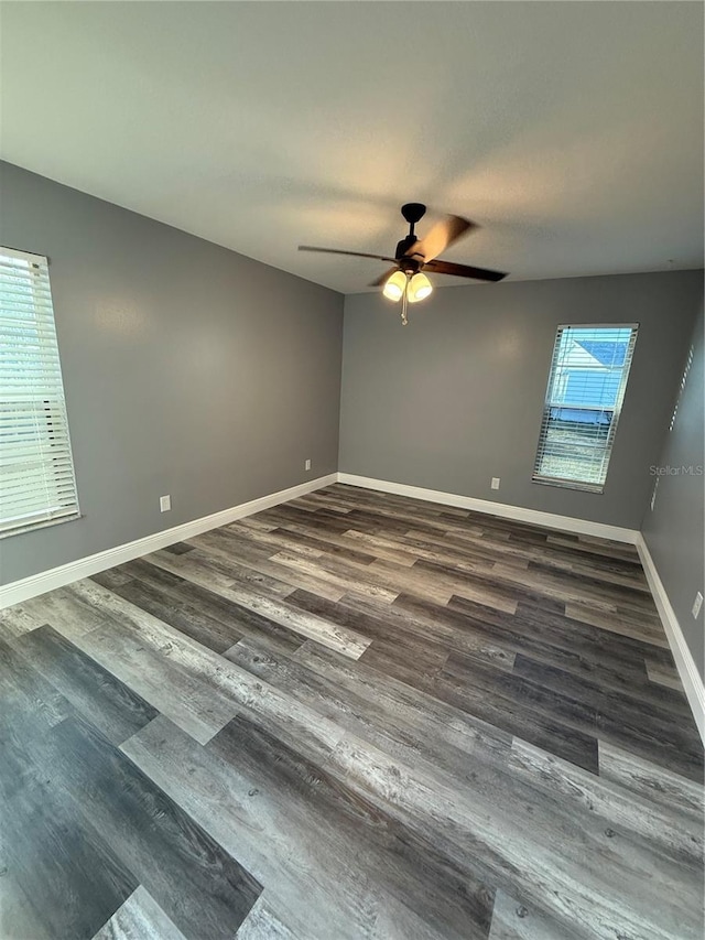 empty room with dark wood-type flooring and ceiling fan