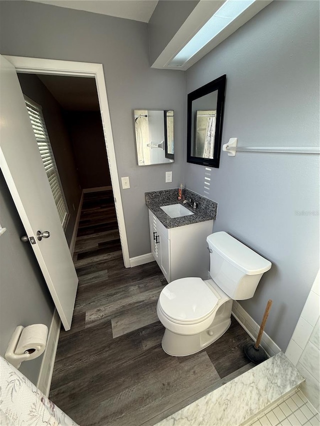 bathroom featuring vanity, hardwood / wood-style flooring, and toilet