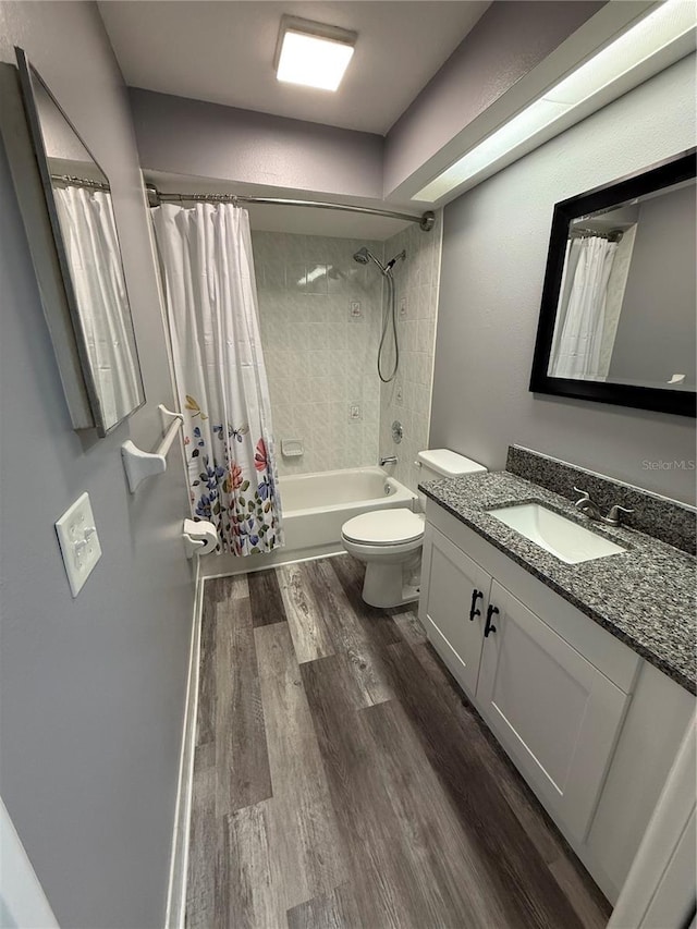 full bathroom featuring shower / bathtub combination with curtain, vanity, hardwood / wood-style flooring, and toilet