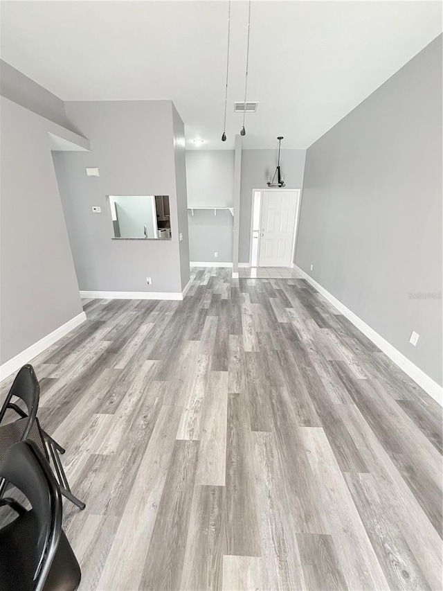4218 San Rafael Ave, New Port Richey, FL 34655 - unfurnished living room with baseboards, visible vents, and light wood-style floors