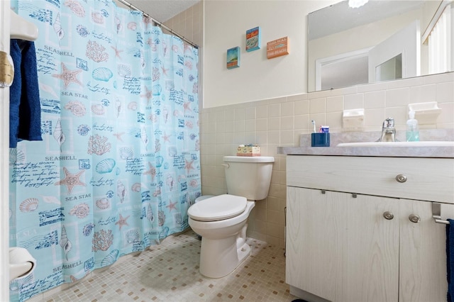 bathroom with tile walls, tile patterned flooring, vanity, curtained shower, and toilet