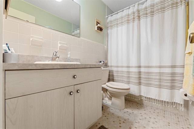 bathroom featuring vanity, toilet, tile patterned flooring, and tile walls