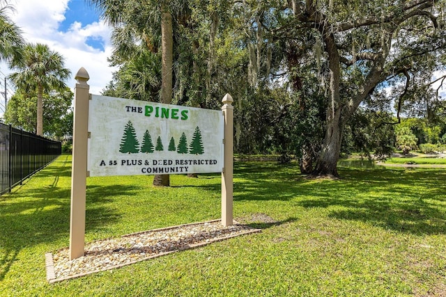 community / neighborhood sign featuring a lawn