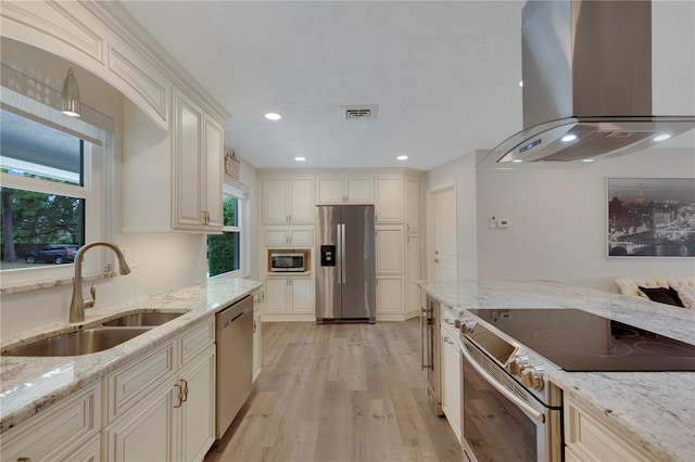 kitchen featuring sink, island exhaust hood, stainless steel appliances, light stone countertops, and light hardwood / wood-style flooring