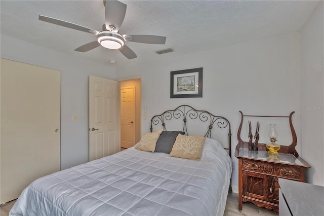 bedroom with a textured ceiling and ceiling fan