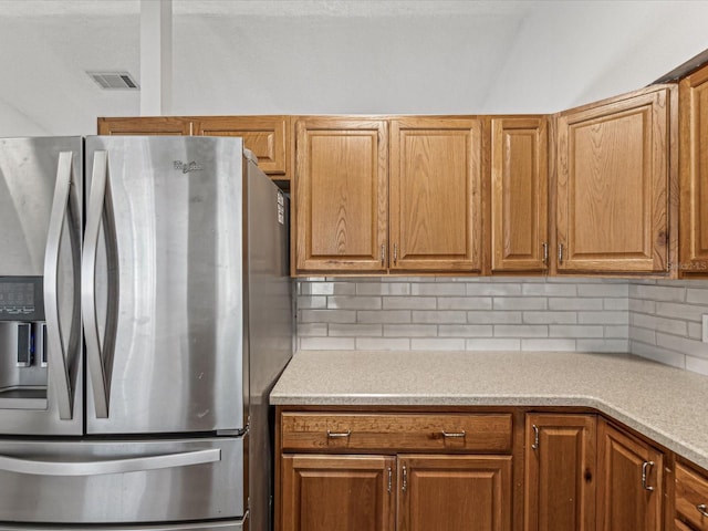 kitchen featuring tasteful backsplash and stainless steel fridge with ice dispenser