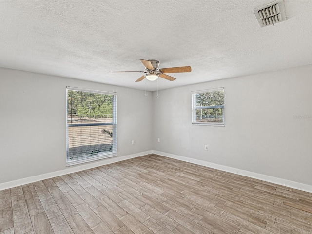 spare room featuring ceiling fan, light hardwood / wood-style floors, and a textured ceiling