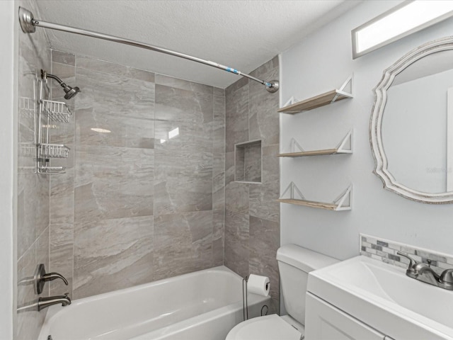 full bathroom with vanity, a textured ceiling, toilet, and tiled shower / bath