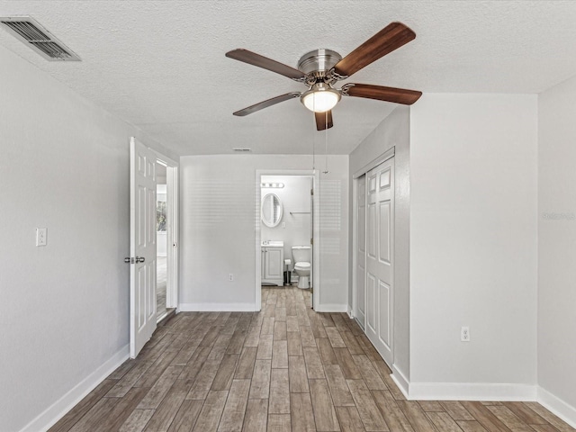 interior space featuring wood-type flooring, ceiling fan, and a textured ceiling