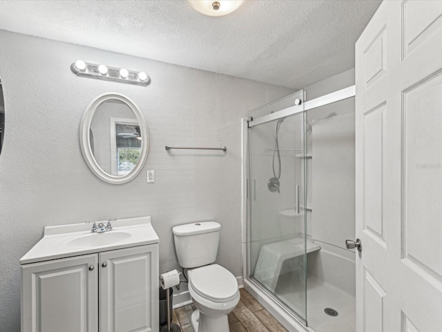 bathroom with an enclosed shower, hardwood / wood-style floors, a textured ceiling, and toilet