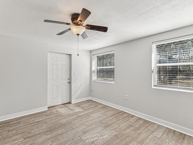 empty room featuring ceiling fan, a textured ceiling, and light wood-type flooring