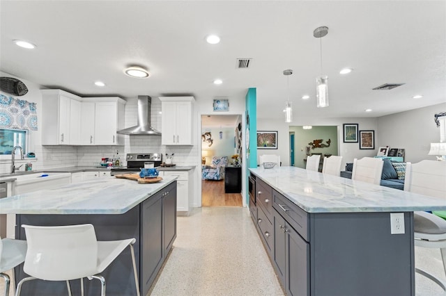 kitchen with white cabinetry, sink, a large island, electric range, and wall chimney exhaust hood