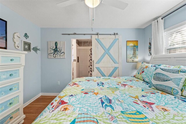 bedroom with ceiling fan, wood-type flooring, and a textured ceiling