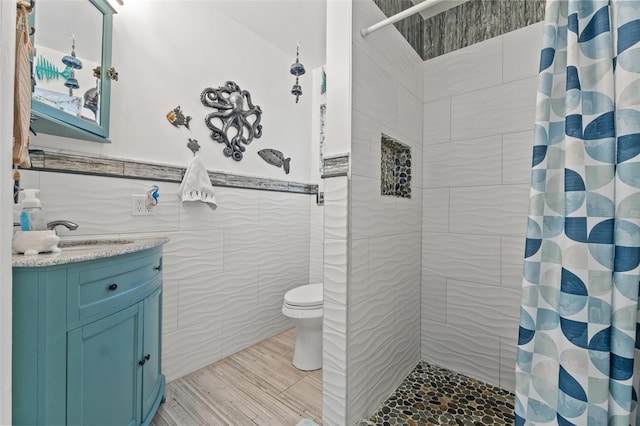 bathroom with toilet, curtained shower, and tile walls