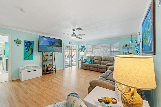 living room with hardwood / wood-style flooring, plenty of natural light, crown molding, and a textured ceiling