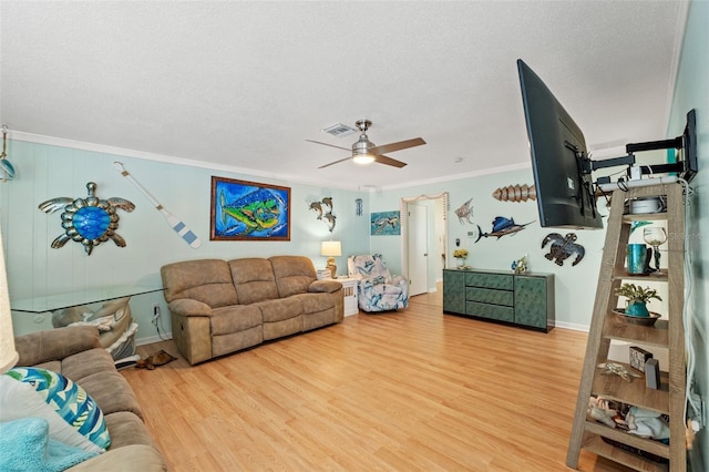 living room featuring crown molding, ceiling fan, hardwood / wood-style floors, and a textured ceiling