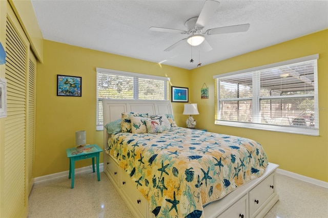 bedroom with ceiling fan, a closet, and a textured ceiling