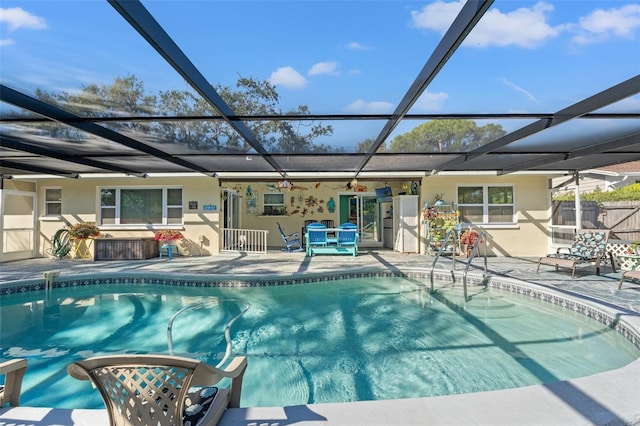 view of swimming pool featuring glass enclosure and a patio area