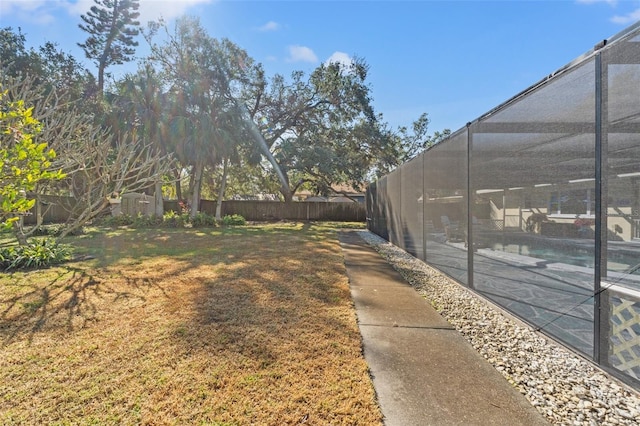 view of yard featuring a swimming pool, a patio area, and glass enclosure