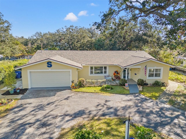 ranch-style home featuring a garage and a front lawn