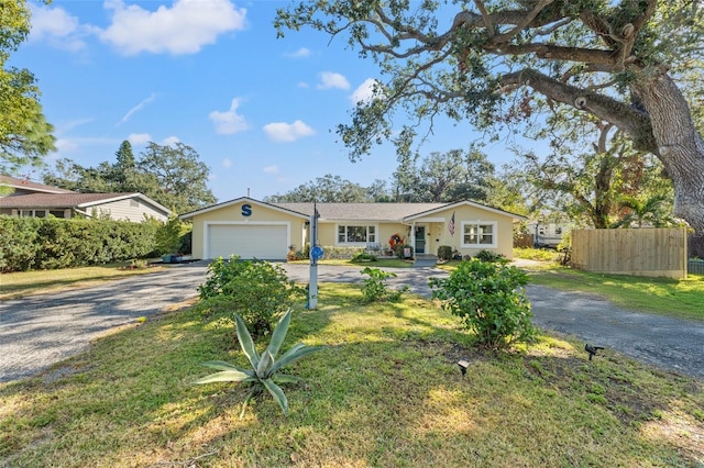 ranch-style house with a garage and a front lawn