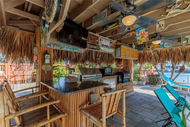 view of patio / terrace featuring a bar, grilling area, and ceiling fan