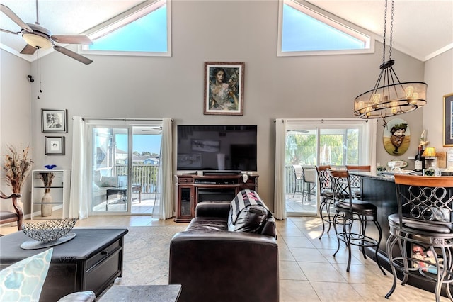 tiled living room with ceiling fan with notable chandelier and high vaulted ceiling