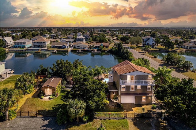 aerial view at dusk featuring a water view