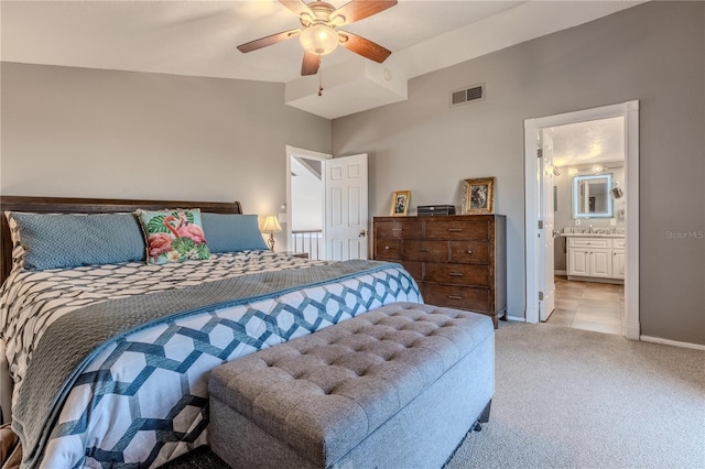 carpeted bedroom featuring lofted ceiling, ensuite bath, and ceiling fan