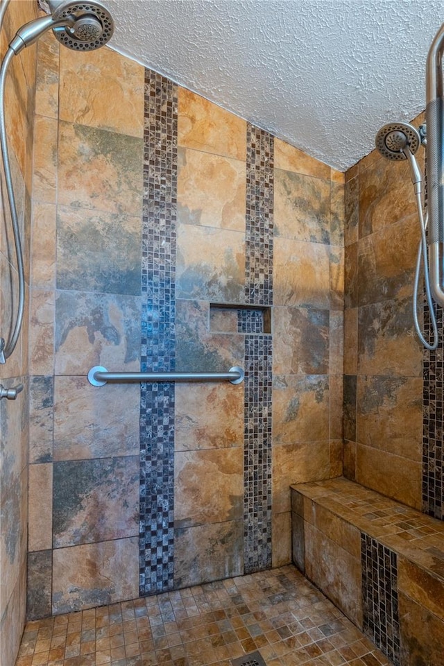 bathroom featuring vaulted ceiling, tiled shower, and a textured ceiling