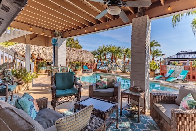 view of patio / terrace featuring a gazebo, ceiling fan, outdoor lounge area, and a fenced in pool