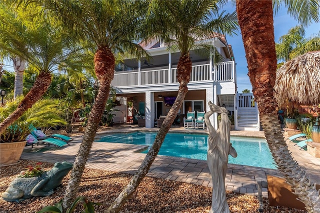 rear view of house with ceiling fan, a balcony, and a patio