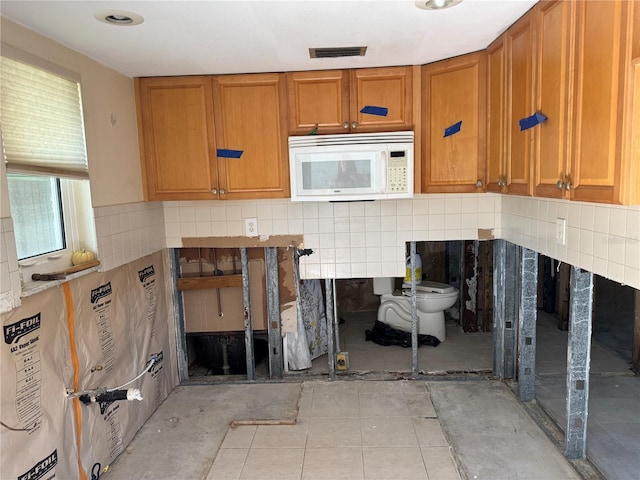 kitchen with tasteful backsplash and light tile patterned floors