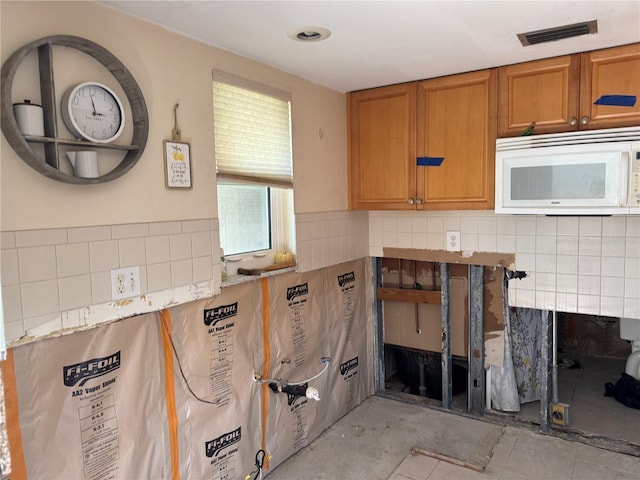 kitchen featuring light tile patterned floors and backsplash