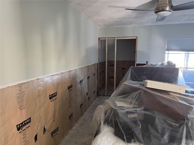 garage featuring ceiling fan and wood walls