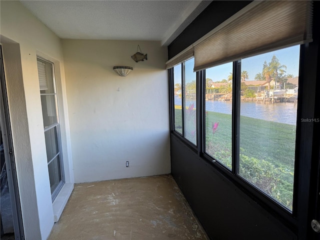 unfurnished sunroom with a water view