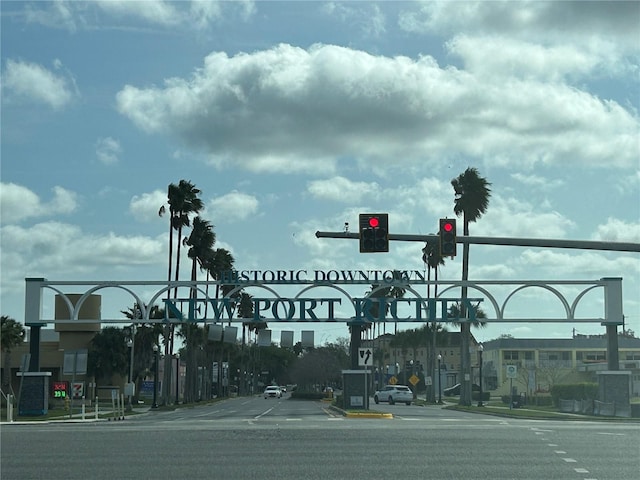 view of road featuring traffic lights, traffic signs, curbs, and sidewalks