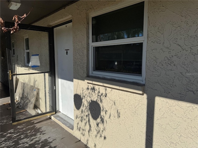 entrance to property with stucco siding