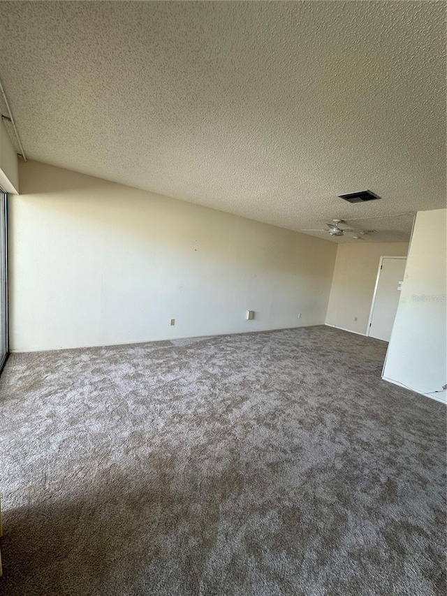 carpeted empty room featuring a textured ceiling