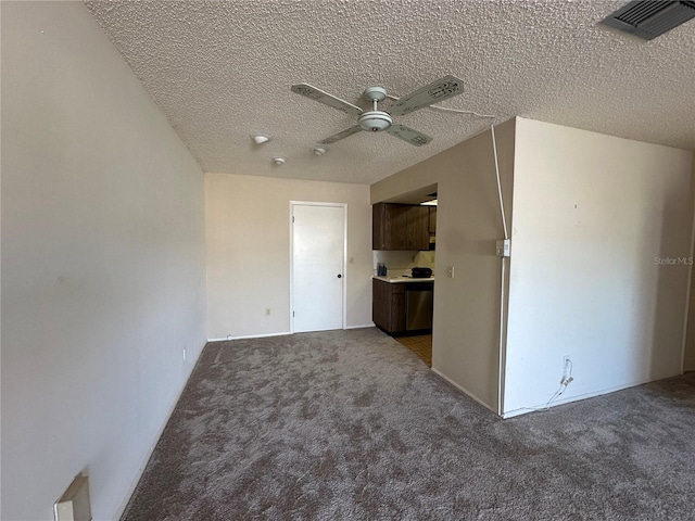 carpeted empty room with ceiling fan and a textured ceiling